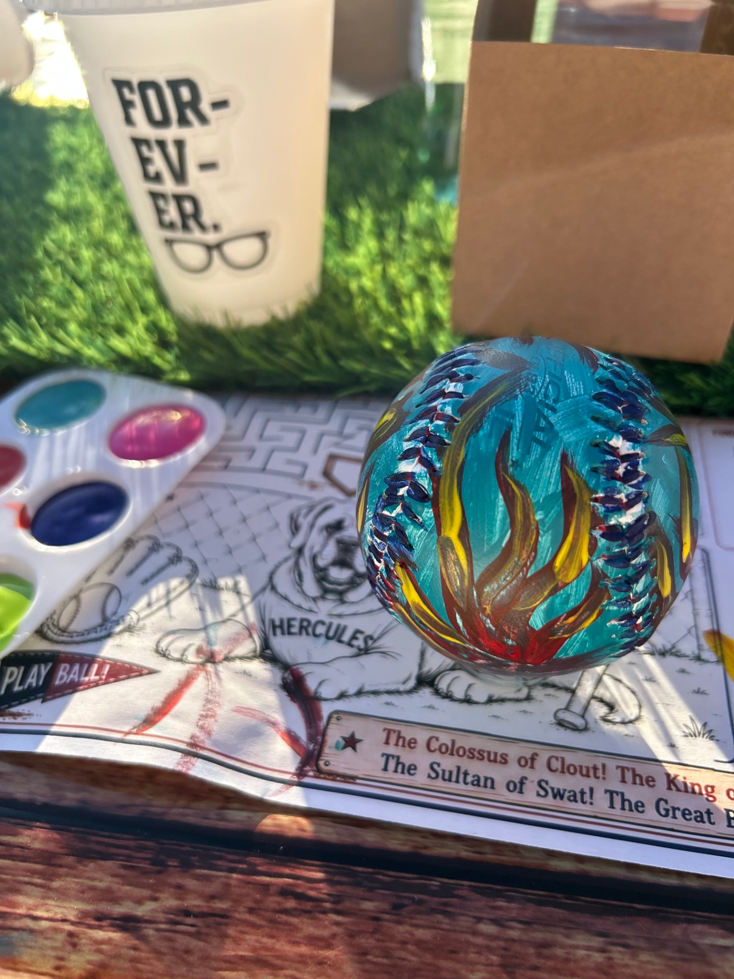 Hand-painted baseball with watercolors on a baseball-themed activity mat