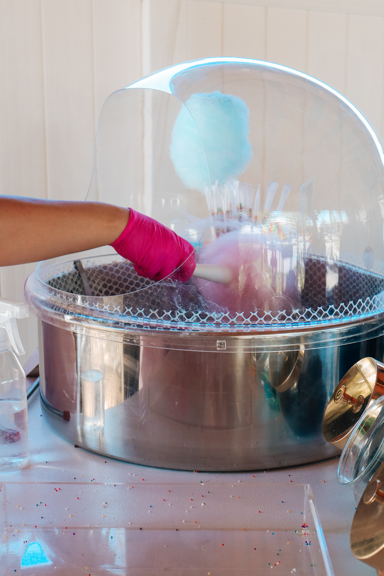 Cotton candy machine spinning pastel blue and pink floss at an event