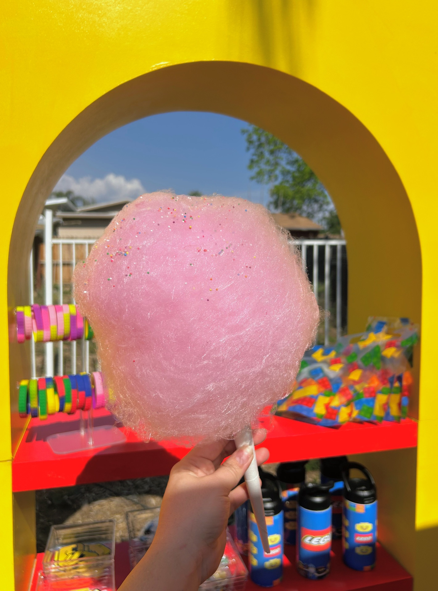Pink cotton candy on a stick at a colorful Lego-themed activation setup